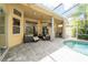 Relaxing lanai with brick floors, comfortable seating, bar, ceiling fan, and access to the sparkling pool at 8376 Golden Prairie Dr, Tampa, FL 33647