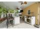 Covered outdoor kitchen with large island and stainless steel appliances at 8376 Golden Prairie Dr, Tampa, FL 33647