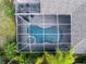 Aerial view of a screened-in pool featuring an attached spa at 8376 Golden Prairie Dr, Tampa, FL 33647