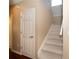 Carpeted staircase with white railing in a hallway with a door and wood floors at 8376 Golden Prairie Dr, Tampa, FL 33647