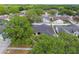 An aerial view of a home with a dark roof and white privacy fence in a neighborhood full of trees at 930 Balsamina Dr, Brandon, FL 33510