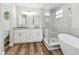 Bathroom features a glass-enclosed shower, soaking tub, double vanity, and wood-look floors at 930 Balsamina Dr, Brandon, FL 33510