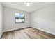 Minimalist bedroom with light-colored walls, wood floors, and a bright window at 930 Balsamina Dr, Brandon, FL 33510