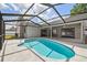 A screened-in pool has a blue interior and a white tile surround in this home's backyard at 930 Balsamina Dr, Brandon, FL 33510