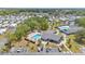Aerial view of a charming community center, sparkling pool, ample parking, and landscaped grounds under a sunny sky at 9790 66Th N St # 160, Pinellas Park, FL 33782