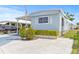 Charming blue home featuring covered parking, landscaped yard, and inviting curb appeal at 9790 66Th N St # 160, Pinellas Park, FL 33782