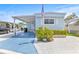 Charming blue home featuring covered parking, landscaped yard, and inviting curb appeal at 9790 66Th N St # 160, Pinellas Park, FL 33782