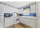 Bright kitchen with white cabinets and appliances and natural light from adjacent windows at 9790 66Th N St # 160, Pinellas Park, FL 33782