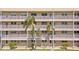Close-up of condo building facade featuring balconies, palm trees and secure access at 9950 62Nd N Ter # 316, St Petersburg, FL 33708