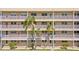 Close-up of condo building facade featuring balconies, palm trees and secure access at 9950 62Nd N Ter # 316, St Petersburg, FL 33708