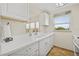 Well-lit kitchen with white cabinets, tile floors, and a window with a pleasant view at 9950 62Nd N Ter # 316, St Petersburg, FL 33708