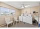 Bright laundry room with ceiling fan, three washing machines, utility sink and two chairs at 9950 62Nd N Ter # 316, St Petersburg, FL 33708