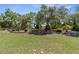 The expansive backyard features a retaining wall and mature trees at 5202 Lydia Ct, Spring Hill, FL 34608