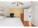 Bedroom with wood floors, a bed, a yellow accent wall, and a doorway to another room at 5202 Lydia Ct, Spring Hill, FL 34608