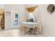 Charming dining area with a lace tablecloth, white chairs, and a view of the outdoor patio through a glass door at 5202 Lydia Ct, Spring Hill, FL 34608