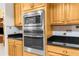 Modern built-in stainless steel microwave and oven combination set within wooden cabinets and above black countertops at 5202 Lydia Ct, Spring Hill, FL 34608