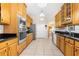 Spacious kitchen featuring wooden cabinets, stainless steel appliances, and tile flooring leading to a dining area at 5202 Lydia Ct, Spring Hill, FL 34608
