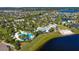 Aerial view of the community pool, clubhouse, and lakefront homes surrounded by lush landscaping and mature trees at 10822 Verawood Dr, Riverview, FL 33579