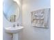 Cozy powder room with pedestal sink, decorative mirror, and neutral-toned towels at 10822 Verawood Dr, Riverview, FL 33579