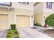 Close-up of the townhome featuring a one-car garage, front yard landscaping, and a well-lit entrance at 10822 Verawood Dr, Riverview, FL 33579