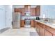 Well-lit kitchen with stainless steel appliances, granite countertops, and rich wood cabinets at 10822 Verawood Dr, Riverview, FL 33579