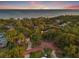 Stunning aerial view of the property surrounded by lush greenery and trees with bay views in the background at 1136 Serpentine S Dr, St Petersburg, FL 33705