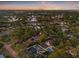 Expansive aerial view of the property showcasing a neighborhood with tree-lined streets, pools and city skyline in the background at 1136 Serpentine S Dr, St Petersburg, FL 33705