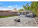 Backyard featuring a paved patio, fire pit, string lights, and a partially covered hot tub at 1136 Serpentine S Dr, St Petersburg, FL 33705