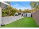 Backyard featuring artificial turf, a shed, paved patio, fire pit, and outdoor movie screen at 1136 Serpentine S Dr, St Petersburg, FL 33705