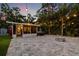 Backyard with lush landscaping, paved patio, hot tub, fire pit, and outdoor lighting at 1136 Serpentine S Dr, St Petersburg, FL 33705