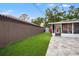 Side yard featuring artificial turf, a privacy fence, paved patio and a screened patio at 1136 Serpentine S Dr, St Petersburg, FL 33705