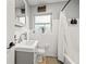 Clean bathroom with white tiled walls, a gray vanity, and a shower/tub combination at 1136 Serpentine S Dr, St Petersburg, FL 33705