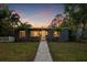 Charming single-story home with a well-manicured lawn, lush tropical landscaping, and a welcoming walkway to the front door at 1136 Serpentine S Dr, St Petersburg, FL 33705