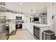 Open kitchen with stainless steel appliances, quartz countertops, and adjacent living area at 1136 Serpentine S Dr, St Petersburg, FL 33705