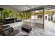 Enclosed patio featuring comfortable seating, hot tub, and a view of the backyard entertainment area at 1136 Serpentine S Dr, St Petersburg, FL 33705
