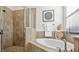 Beautiful bathroom features a glass-enclosed shower and soaking tub under a window with blinds at 11412 Autumn Leaf Way, Bradenton, FL 34212