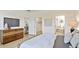 Bright bedroom features a modern dresser, flatscreen TV, and views to the bathroom and closet at 11412 Autumn Leaf Way, Bradenton, FL 34212