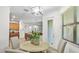 Bright breakfast nook features a round table with seating for four, a modern light fixture, and a large window at 11412 Autumn Leaf Way, Bradenton, FL 34212