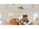 Cozy living room with leather sofa, stylish seating, modern ceiling fan, and seamless flow to the kitchen at 11412 Autumn Leaf Way, Bradenton, FL 34212