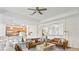 Spacious living room with archway to the kitchen, featuring modern furnishings, a ceiling fan, and lots of natural light at 11412 Autumn Leaf Way, Bradenton, FL 34212
