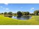 Backyard view of a lush green lawn and peaceful private pond at 11412 Autumn Leaf Way, Bradenton, FL 34212