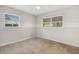 Bright bedroom features neutral walls, carpeted floors, and two windows to provide natural light at 1250 12Th Sw Ct, Largo, FL 33770
