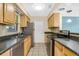 Functional kitchen with stainless steel appliances, tile flooring, and ample cabinet space at 1250 12Th Sw Ct, Largo, FL 33770