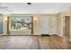 Bright living room showcasing wood-look floors, a large window, and a welcoming front door at 1250 12Th Sw Ct, Largo, FL 33770