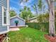 Grassy backyard showcases a detached garage plus lush bamboo and tree coverage at 1403 W Watrous Ave, Tampa, FL 33606