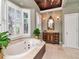 Bathroom featuring garden tub with jets, shuttered windows, and traditional vanity at 1403 W Watrous Ave, Tampa, FL 33606