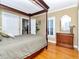 Bedroom features a four-poster bed, hardwood floors, plantation shutters, and ample natural light at 1403 W Watrous Ave, Tampa, FL 33606
