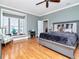 Primary bedroom with hardwood floors, ceiling fan, and bay window with plantation shutters at 1403 W Watrous Ave, Tampa, FL 33606