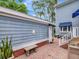 Charming home exterior showcases brick accents, blue siding, and a cozy patio at 1403 W Watrous Ave, Tampa, FL 33606