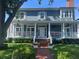 Charming two-story home featuring a welcoming front porch with swing, manicured lawn, and brick walkway at 1403 W Watrous Ave, Tampa, FL 33606